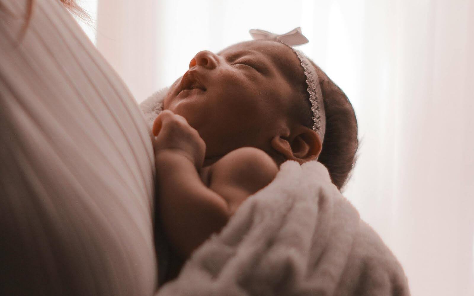 Newborn baby resting in mother’s arms – first moments of life and care